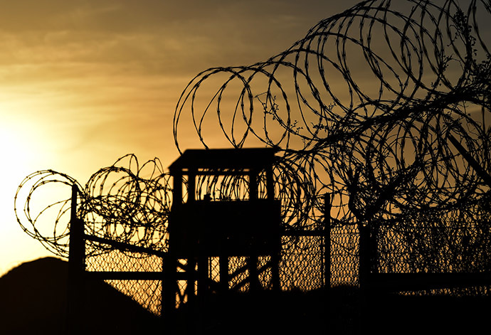 This photo made during an escorted visit and reviewed by the US military, shows the razor wire-topped fence and a watch tower at the abandoned "Camp X-Ray" detention facility at the US Naval Station in Guantanamo Bay, Cuba. (AFP Photo/Mladen Antonov)