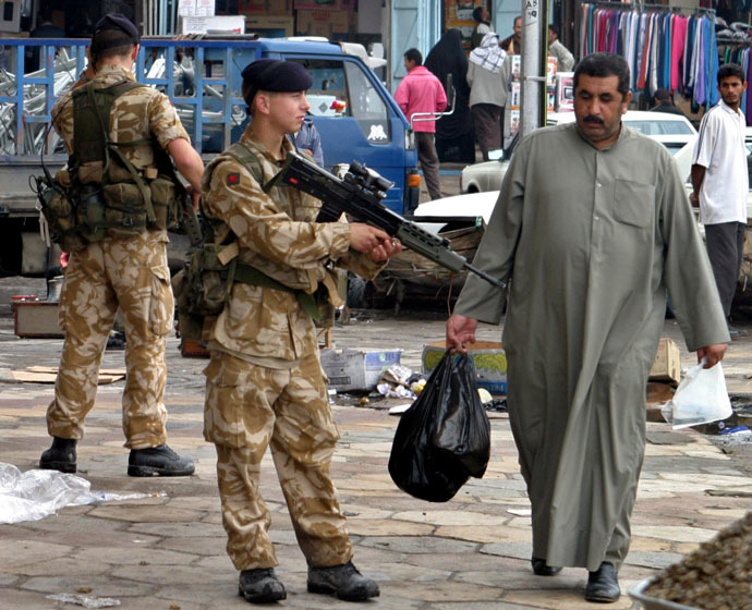 An Iraqi man passes British soldiers patrolling the streets in the southern city of Basra, some 600 km of Baghdad December 6, 2003. (Reuters/Atef Hassan)