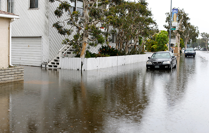A parked automobile is surrounded by water as a winter storm brings rain and high winds to San Diego, California December 12, 2014 (Reuters / Mike Blake)