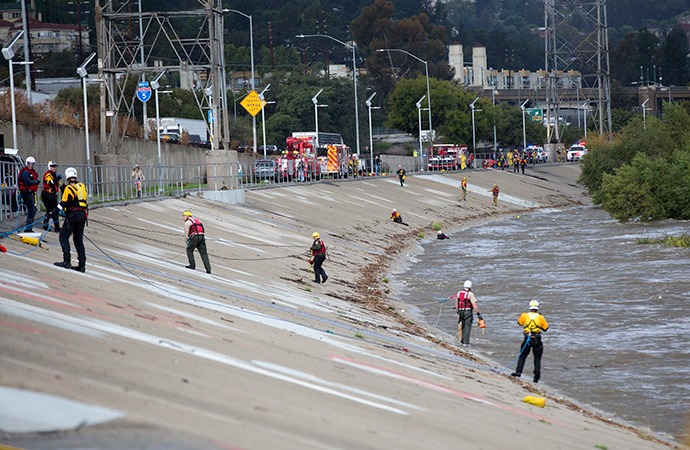 Los Angeles Fire Department personnel stand by next to the Los Angeles river during a rescue operation in Los Angeles, California December 12, 2014 (Reuters / Mario Anzuoni)