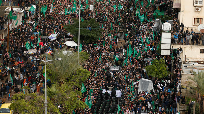 People watch as Palestinian members of al-Qassam Brigades, the armed wing of the Hamas movement, take part in a military parade marking the 27th anniversary of Hamas' founding, in Gaza City December 14, 2014. (Reuters / Suhaib Salem) 