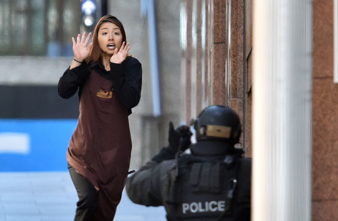 One of the hostages runs towards police from a cafe in the central business district of Sydney on December 15, 2014. (AFP Photo/Saeed Khan)