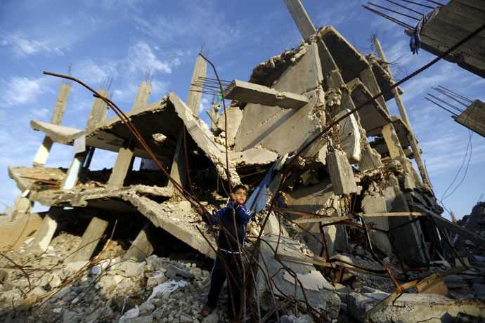 A Palestinian boy plays in the rubble of a house destroyed during the 50 days of conflict between Israel and Hamas last summer, in the Shejaiya neighborhood of Gaza City, on Decembre 11, 2014. (AFP Photo)