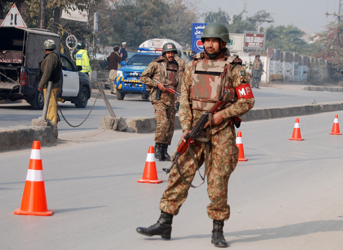 Pakistani security forces takes up positions on a road leading to the Army Public School that is under attack by Taliban gunmen in Peshawar, December 16, 2014. (Reuters/Khuram Parvez)