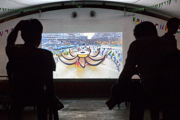 People watch a television projection of a live telecast displaying the opening ceremony of the 2014 FIFA World Cup in Brazil, on June 13, 2014 (AFP Photo)