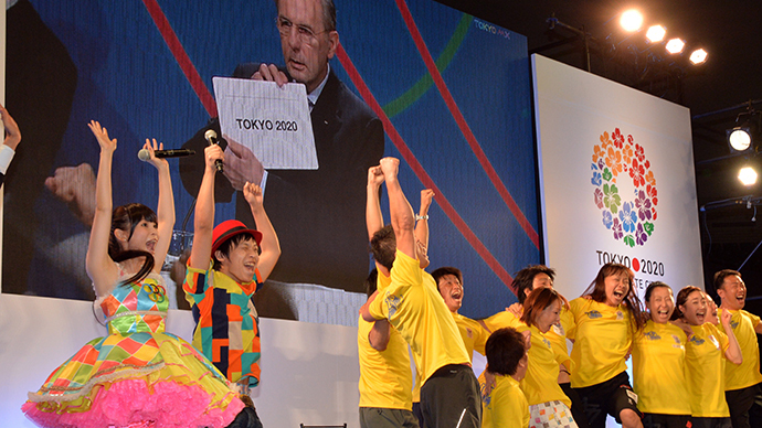 People celebrate as IOC President Jacques Rogge announces Tokyo for the 2020 Olympics host city on a screen at the live-viewing event in Tokyo on September 8, 2013. (AFP Photo / Yoshikazu Tsuno)