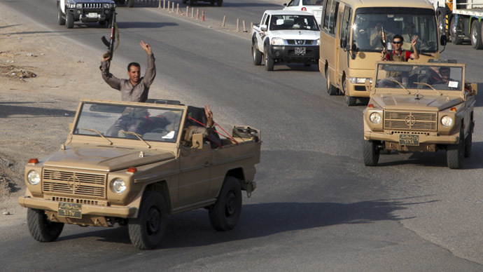 A convoy of Kurdish peshmerga fighters drive through Arbil after leaving a base in northern Iraq, on their way to the Syrian town of Kobani (Reuters)