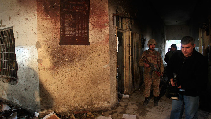 A local cameraman films in front of an army soldier at the Army Public School, which was attacked by Taliban gunmen, in Peshawar, December 17, 2014.(Reuters / Fayaz Aziz)
