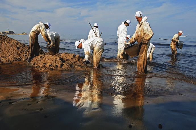 Members of the Lebanese Non-Governmental Organisation Bahr Lubnan (Lebanon's Sea) clean the oil spill at a beach in Jieh, south of Beirut, 26 October 2006. (AFP Photo / Marwan Naamani)