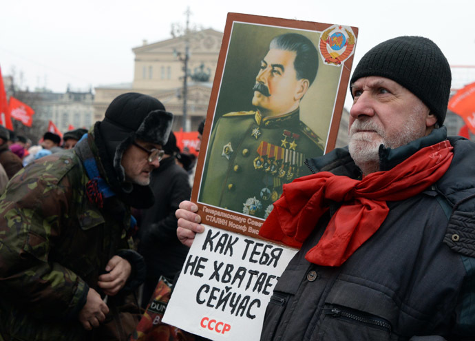A Russia's communists supporter holds a portrait of Soviet dictator Stalin with a slogan "We miss you so much, USSR" during a rally in central Moscow. (AFP Photo/Vasily Maximov)
