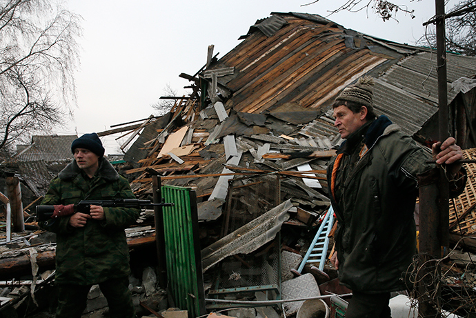 A rebel and a local citizen stand in front of a house, which according to locals was destroyed by shelling last week, in the town of Gorlovka northeast of Donetsk December 14, 2014 (Reuters / Maxim Shemetov)