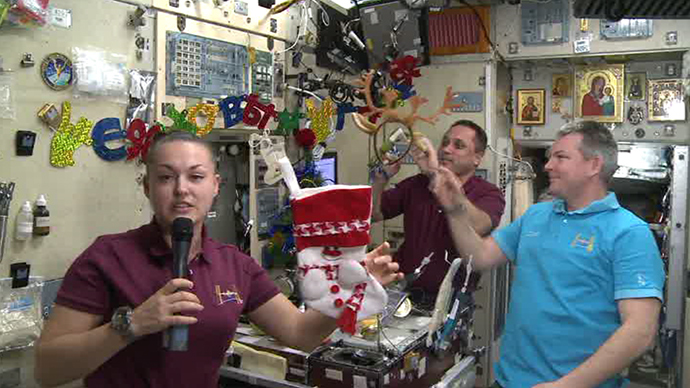 Elena Serova showing off traditional New Year symbols the ISS crew prepared for the festive celebrations: a tree, stockings and reindeer antlersâ headband.