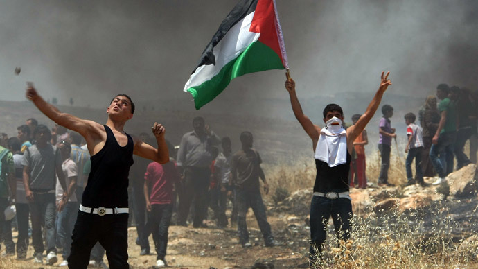 Palestinian protestors stand amidst smoke during clashes with Israeli forces following a demonstration against Israeli settlements in the West Bank village of Dair al-Hatab.(AFP Photo / Jaafar Ashtiyeh)