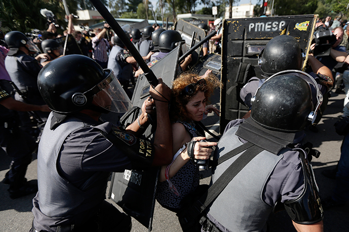 A woman is pushed by riot policemen during a clash with demontrators in a protest against the 2014 World Cup in Sao Paulo June 12, 2014. (Reuters / Ricardo Moraes)