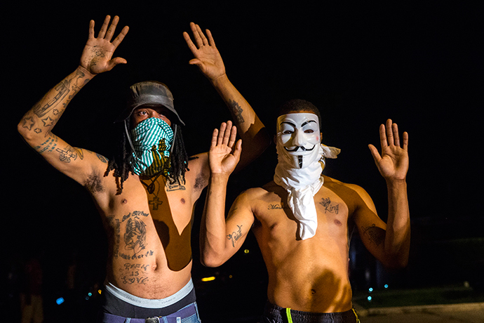 Members of a rowdy group of demonstrators stand with their hands up as they are lit by a police spotlight on West Florissant during protests in reaction to the shooting of Michael Brown near Ferguson, Missouri August 18, 2014. (Reuters / Lucas Jackson)