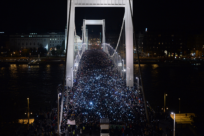 Ten-thousand participants march accross the Elisabeth bridge during an anti-government rally against the goverment's new tax plan for the introduction of the internet tax next year in Budapest on October 28, 2014. (AFP Photo / Attila Kisbenedek)