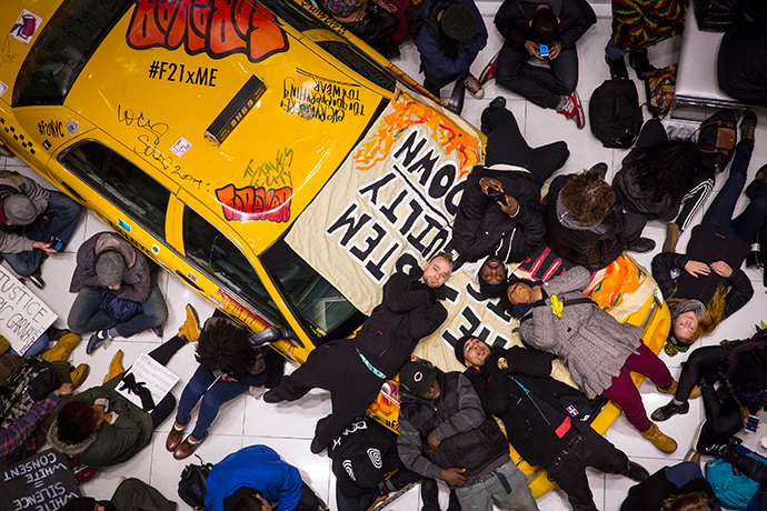 Protesters stage a "Die-In" on a display taxi cab in the Forever 21 store in Times Square, during a march against police violence, in New York, December 7, 2014. (Reuters / Andrew Kelly)