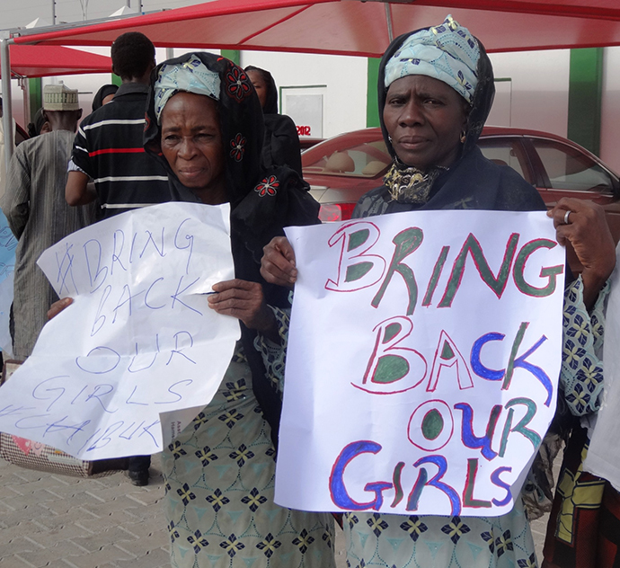 Two women in black veils display placards outside the governor's office in the northern Nigerian city of Kano on April 30, 2014, calling for the release of at least 187 school girls abducted by Boko Haram Islamists in northeastern town of Chibok in an April 14 raid on a girls boarding school. (AFP Photo / Aminu Abubakar)