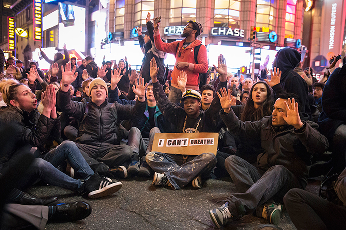 Protesters, demanding justice for the death of Eric Garner, disrupt traffic while raising their hands during a "sit-in" at an intersection in Times Square, Manhattan, New York December 3, 2014. (Reuters / Elizabeth Shafiroff)