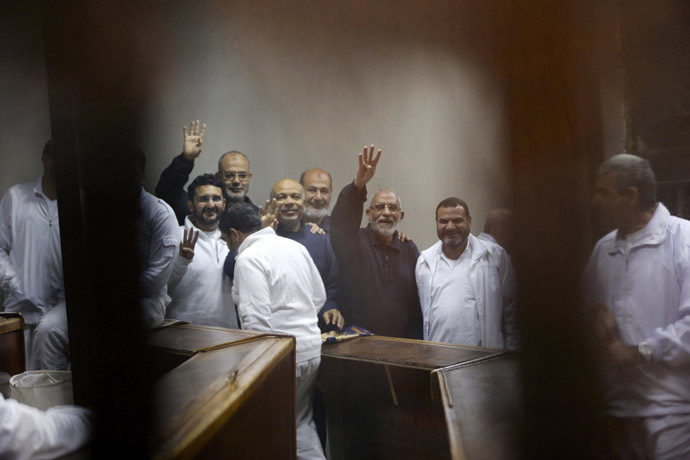 Muslim Brotherhood's Supreme Guide Mohamed Badie (3rd R) waves with the Rabaa sign, symbolizing support for the Muslim Brotherhood, with other brotherhood members at a court in the outskirts of Cairo December 14, 2014. (Reuters/Asmaa Waguih)