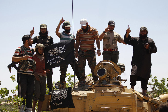 Islamist Syrian rebel group Jabhat al-Nusra members gesture while posing on a tank on Al-Khazan frontline of Khan Sheikhoun, northern Idlib province. (Reuters/Hamid Khatib)