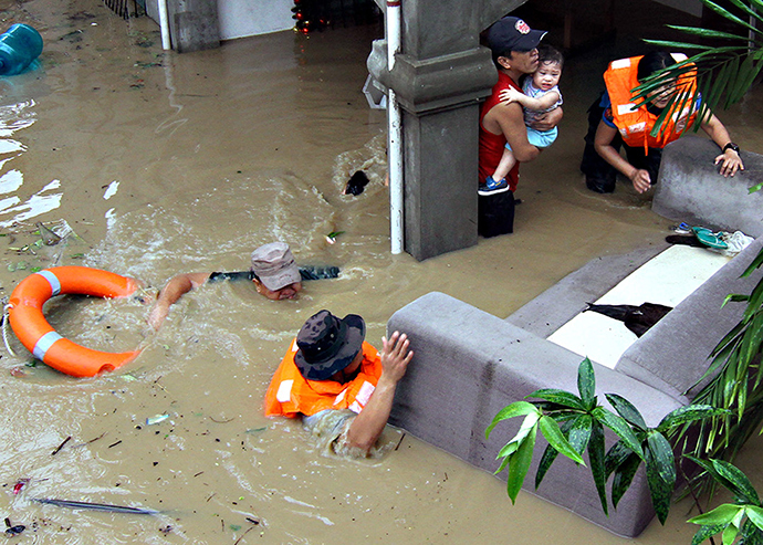 Policemen evacuate families trapped in their home during heavy flooding brought by tropical storm Seniang in Misamis Oriental, Mindanao island in southern Philippines December 29, 2014 (Reuters / Erwin Frames)