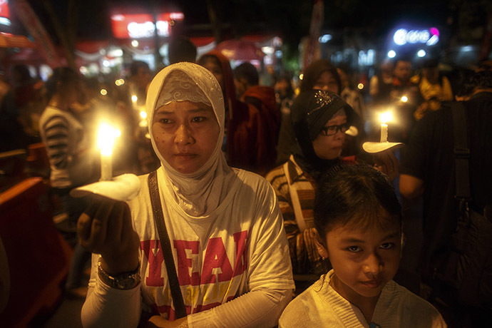 Indonesians hold up candles during a candle light vigil for the victims of AirAsia flight QZ8501 at Surabaya December 31, 2014. (Reuters/Athit Perawongmetha)