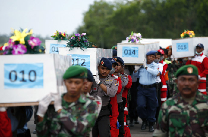 Caskets containing the remains of AirAsia QZ8501 passengers recovered from the sea are carried to a military transport plane before being transported to Surabaya, where the flight originated, at the airport in Pangkalan Bun, Central Kalimantan January 2, 2015. (Reuters/Darren Whiteside)