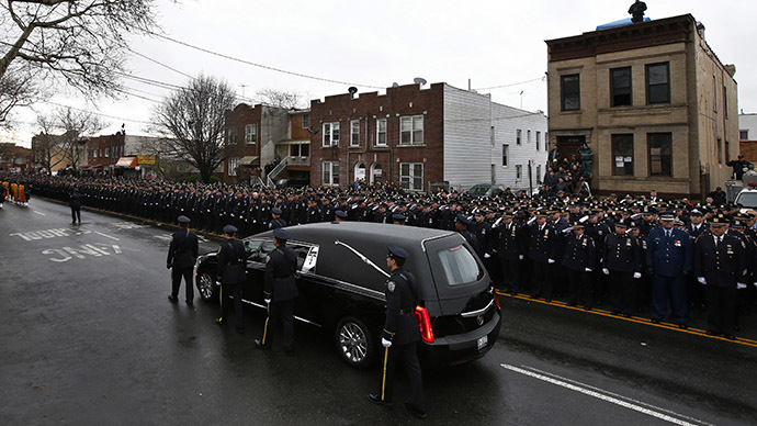 A hearse carrying the casket containing New York Police Department officer Wenjian Liu makes its way in a procession down 65th Street following his funeral service in the Brooklyn borough of New York January 4, 2015. (Reuters/Mike Segar)