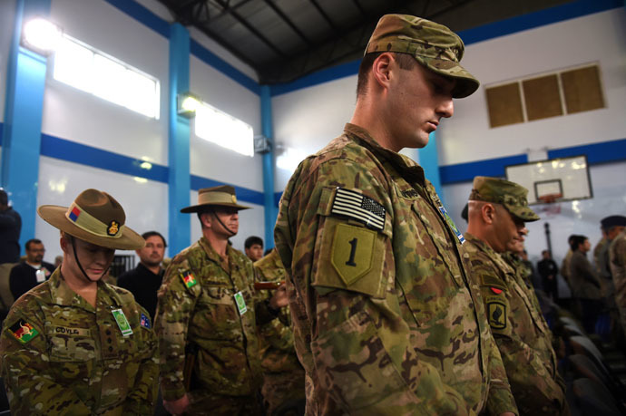 NATO-led International Security Assistance Force (ISAF) bow their heads during a ceremony marking the end of ISAF's combat mission in Afghanistan at ISAF headquarters in Kabul on December 28, 2014. (AFP Photo/Shah Marai)