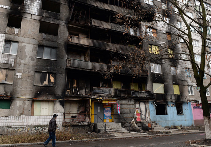 A man walks past the damaged residential building in the eastern Ukrainian city of Shakhtarsk on December 21, 2014. (AFP Photo/Vasily Maximov)