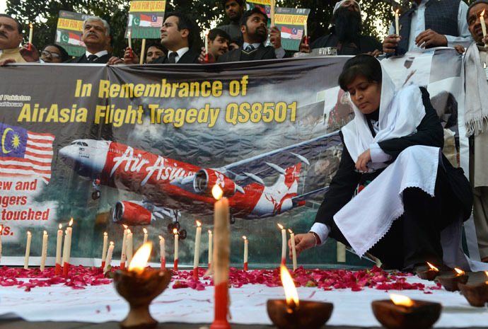 Pakistani civil society activists hold candles during a vigil for the victims of AirAsia Flight 8501 in Lahore on January 2, 2015. (AFP Photo)