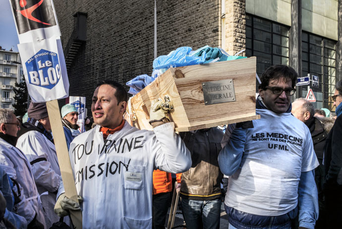 French general practitioners carry a coffin filled with medical outfits as they demonstrate, on January 5, 2015 in Lyon,s to protest against a upcoming health bill centred around a change to the system of payments. (AFP Photo)