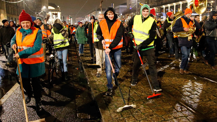 Participants of an alternative rally use brooms as they protest against a demonstration called by anti-immigration group PEGIDA, a German abbreviation for "Patriotic Europeans against the Islamization of the West", in Dresden January 5, 2015.(Reuters / Fabrizio Bensch)
