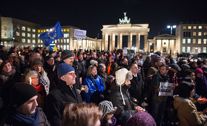 People stand near Berlin's landmark the Brandenburg Gate during a spontaneous vigil outside the French embassy on January 7, 2015 in Berlin to express solidarity with employees of the French satirical weekly Charlie Hebdo that has been target of an attack by unknown gunmen. (AFP Photo/Bernd Von Jutrczenka)