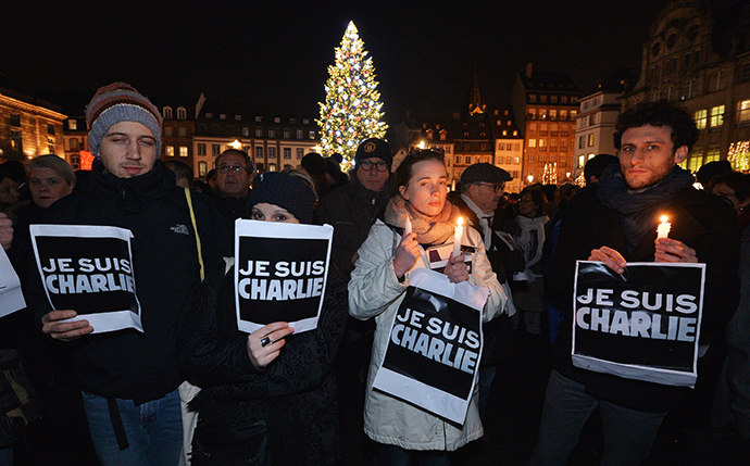 People hold placards reading in French "I am Charlie" during a gathering in Strasbourg, eastern France, on January 7, 2015(AFP Photo / Patrick Hertzog)