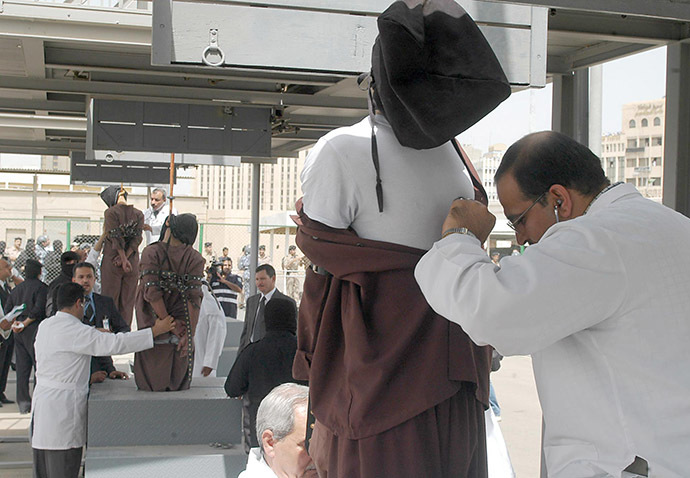 Doctors check the vital signs of two people, as they dangle from the gallows in Kuwait City (AFP Photo/Yasser Al-Zayyat)