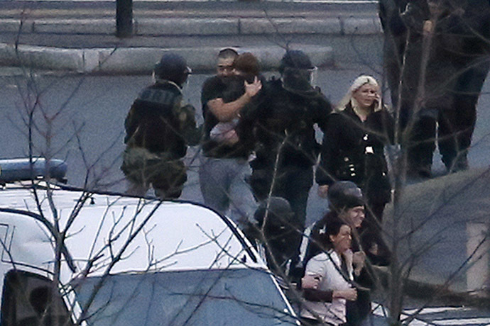 Police evacuate hostages after launching an assault at a kosher grocery store in Porte de Vincennes, eastern Paris, on January 9, 2015. (AFP Photo/Thomas Samson)