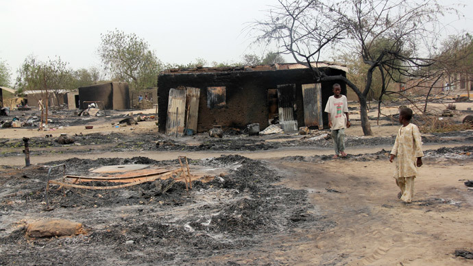 Children walking outside a charrred house in the remote northeast town of Baga, Borno State, after two days of clashes between officers of the Joint Task Force and members of the Islamist sect Boko Haram.(AFP Photo / STR)