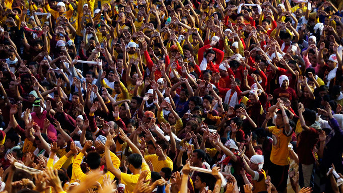 Devotees raise their hands as they pray before the start of the annual procession of the Black Nazarene in Manila, January 9, 2015. (Reuters / Erik De Castro)
