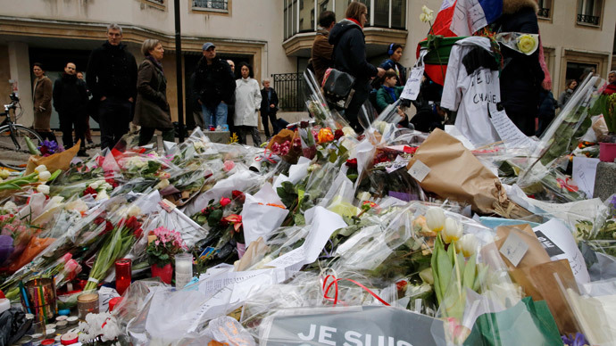 Flowers and messages left by citzens who pay tribute in front of the offices of the weekly satirical newspaper Charlie Hebdo in Paris January 10, 2015.(Reuters / Pascal Rossignol)