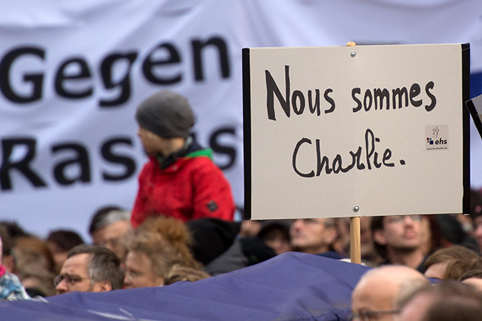 A poster reading "Nous sommes Charlie" (We are Charlie) can be seen as thousands of people take part in a rally themed "For Dresden, for Saxony - living together in the sense of a global awareness, humanity and dialogue " on January 10, 2015 in front of the Frauenkirche (Church of Our Lady) in Dresden, eastern Germany (AFP Photo / DPA)