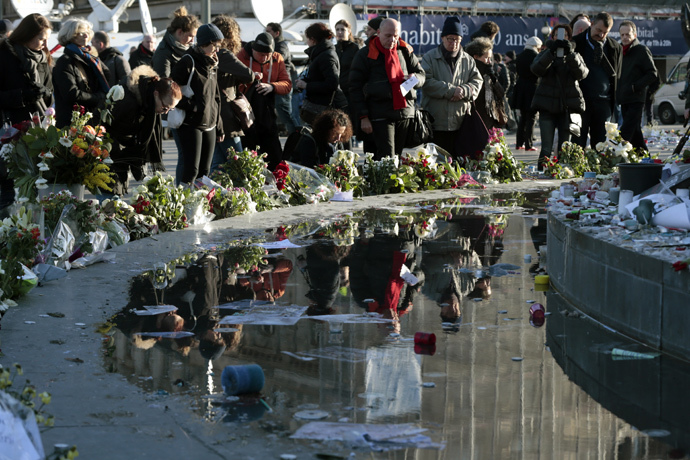 People gather at the foot of the centrepiece of Place de la Republique, a statue of Marianne, in east Paris on January 11, 2015 prior to a huge march. (AFP Photo / Joel Saget)