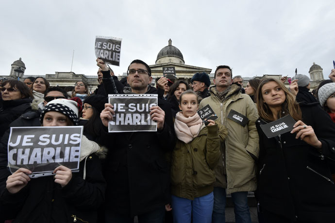 People hold signs that reads "Je suis Charlie" (I am Charlie) and pens during a gathering in Trafalgar Square in central London on January 11, 2015 to commemorate the victims of the attacks in France that killed 17 people and injured scores more. (AFP Photo)