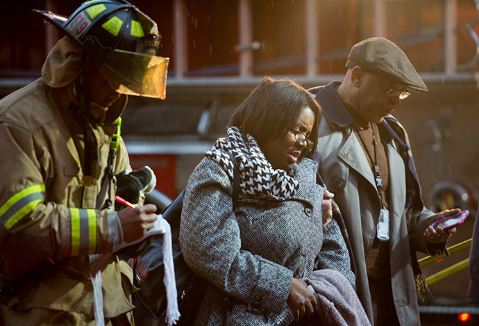 Smoke inhalation victims walk past a firefighter towards a medical aid bus after passengers on the Metro (subway) were injured when smoke filled the L'Enfant Plaza station during the evening rush hour January 12, 2015 in Washington, DC. (AFP Photo/Paul J. Richards)