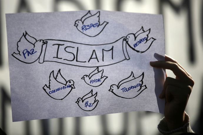 A girl holds up a sign during a rally by members of the Muslim community of Madrid on January 11, 2015. (Reuters)