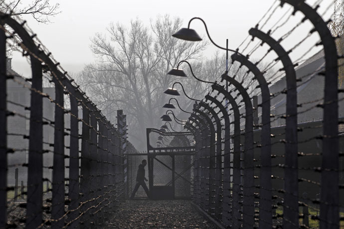 A visitor walks between electric barbed-wired fences at the Auschwitz-Birkenau memorial and former concentration camp (Reuters/Kacper Pempel)