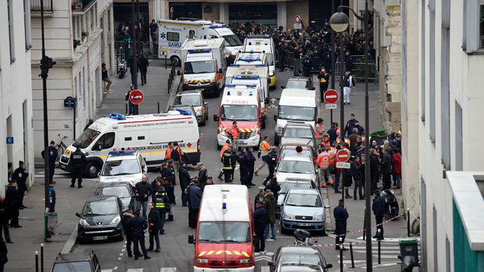 A general view shows firefighters, police officers and forensics gathered in front of the offices of the French satirical newspaper Charlie Hebdo in Paris on January 7, 2015.(AFP Photo / Martin Bureau)