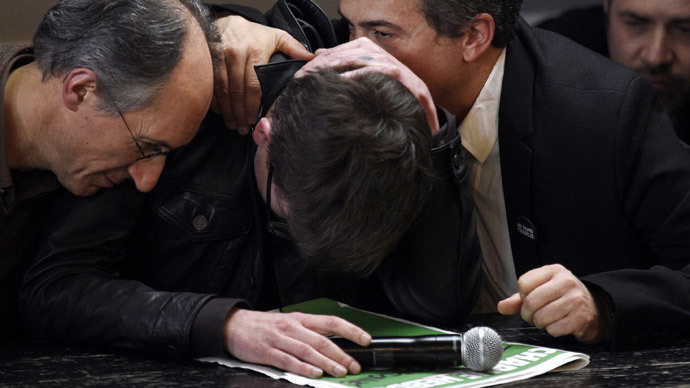French cartoonist Renald Luzier, aka Luz (C), is comforted by editor in chief of French satirical weekly Charlie Hebdo Gerard Briard (L) and editorialist Dr Patrick Pelloux, during a press conference to present the new issue of the weekly at the offices of French newspaper Liberation in Paris on January 13, 2015. (AFP Photo / Martin Bureau)