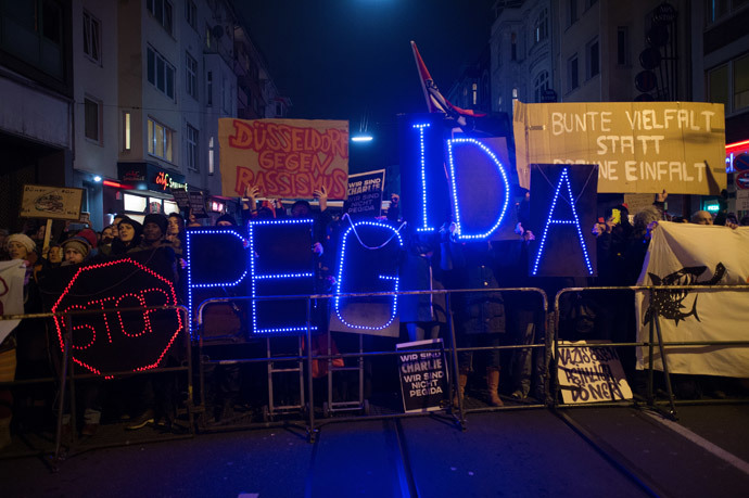 People hold an illuminated sign reading 'Stop PEGIDA', Germany's new anti-Islamic "Patriotic Europeans Against the Islamisation of the Occident" during a counter-rally on January 12, 2015 in Duesseldorf. (AFP Photo / DPA / Federico Gambarini)